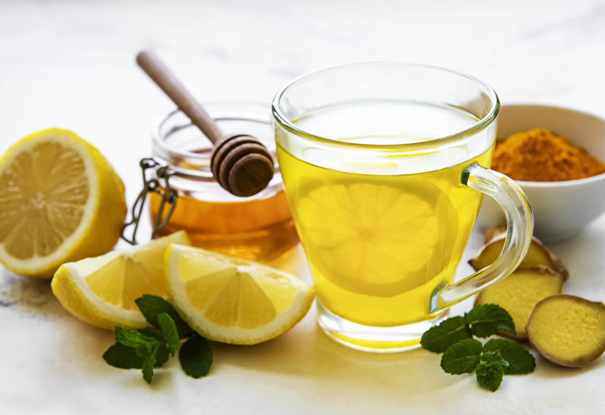 Tasse de boisson au gingembre et au citron, racines de gingembre, miel et curcuma
